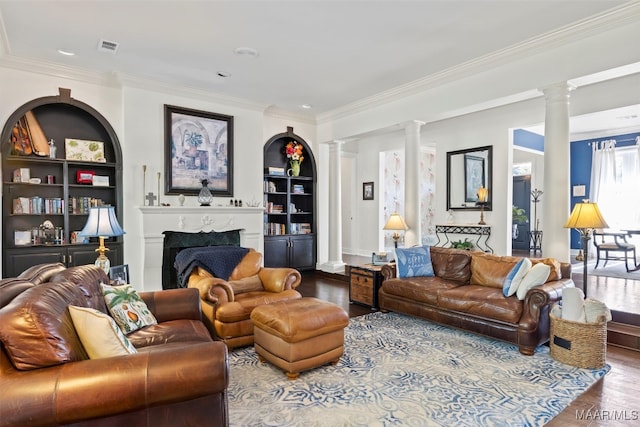 living room featuring built in features, ornamental molding, hardwood / wood-style flooring, and ornate columns