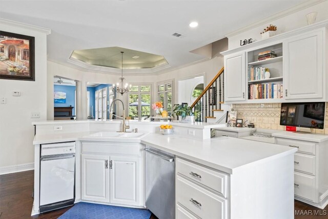 kitchen with dark hardwood / wood-style floors, a notable chandelier, a tray ceiling, sink, and white cabinetry