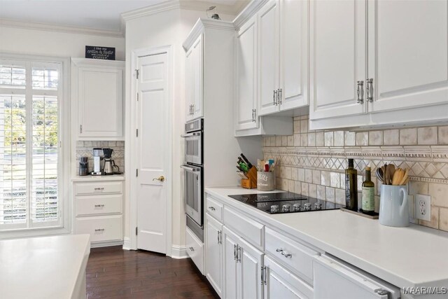 kitchen featuring black electric stovetop, backsplash, plenty of natural light, and white cabinetry