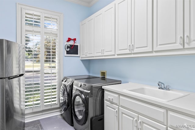 washroom featuring cabinets, tile patterned flooring, washing machine and clothes dryer, ornamental molding, and sink