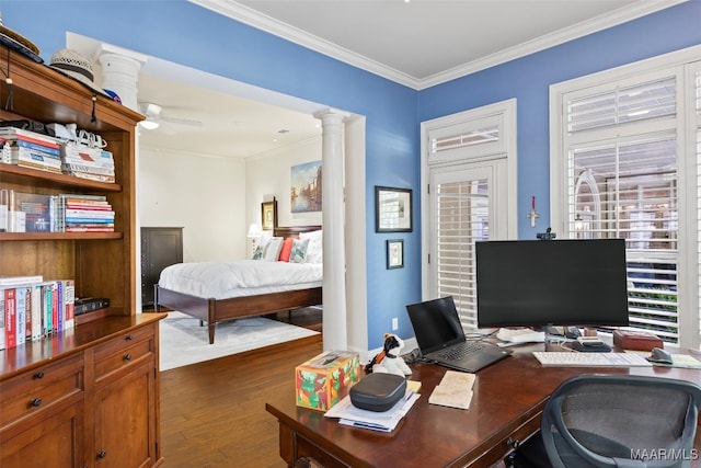 office featuring dark wood-type flooring, decorative columns, crown molding, and ceiling fan