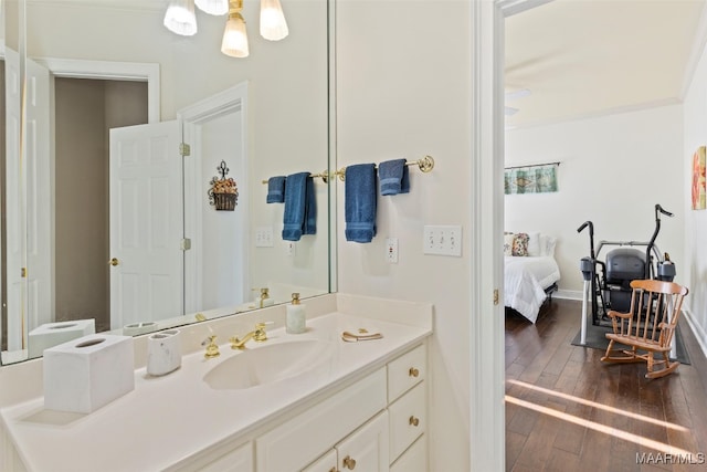 bathroom featuring vanity, hardwood / wood-style flooring, and ornamental molding