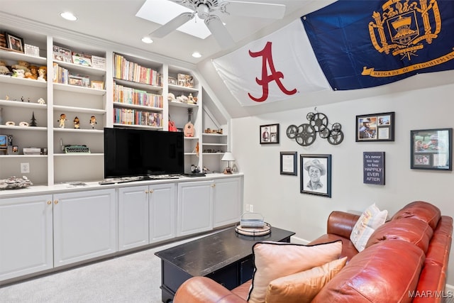 carpeted living room with lofted ceiling, ceiling fan, and built in shelves