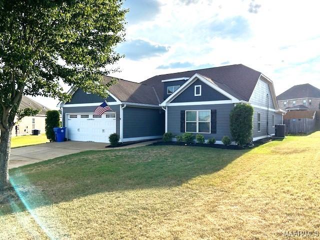 view of front facade with a garage, central AC unit, and a front lawn