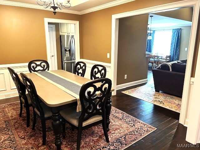 dining area with ornamental molding, dark hardwood / wood-style flooring, and a chandelier