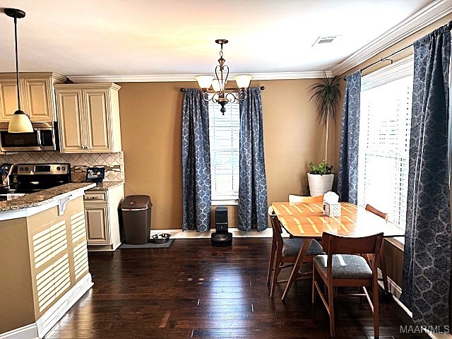 dining room featuring a chandelier, a wealth of natural light, dark hardwood / wood-style flooring, and ornamental molding