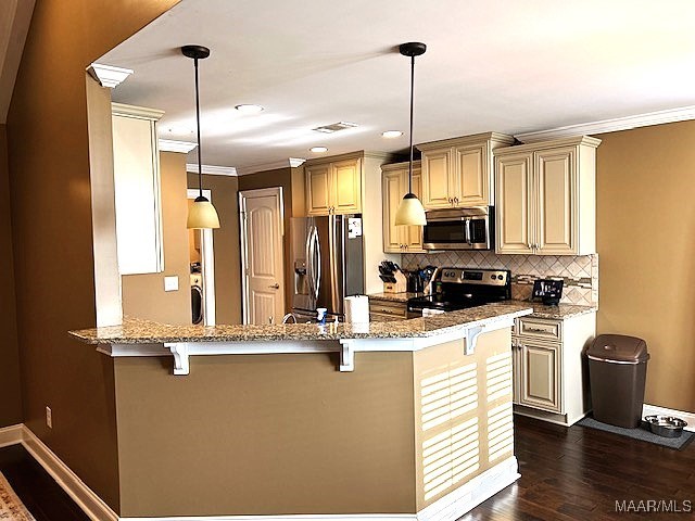 kitchen with decorative light fixtures, appliances with stainless steel finishes, dark hardwood / wood-style flooring, kitchen peninsula, and decorative backsplash