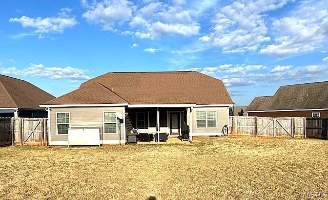 back of house featuring a lawn and a patio