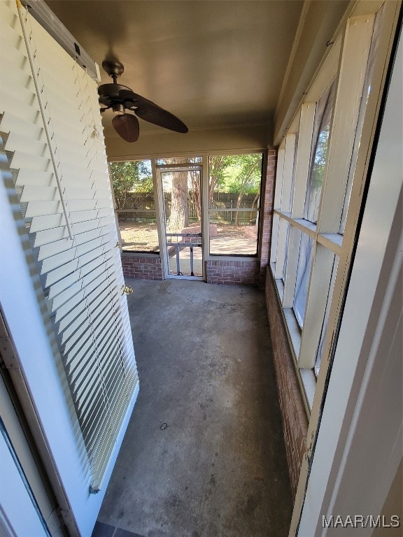 unfurnished sunroom with ceiling fan