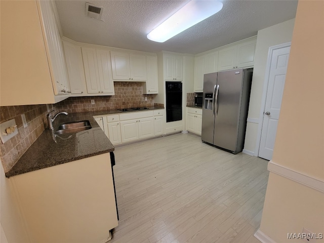 kitchen featuring black appliances, light hardwood / wood-style flooring, sink, decorative backsplash, and white cabinets