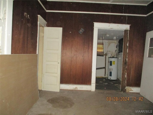 interior space featuring water heater and wood walls