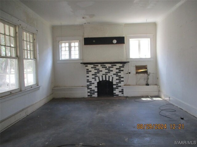 unfurnished living room with a fireplace, crown molding, and baseboards