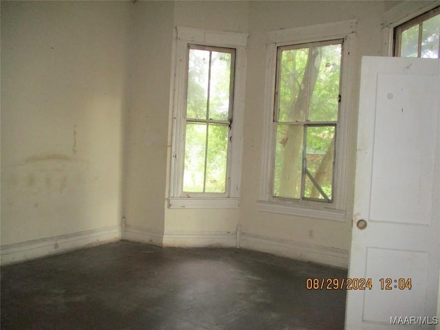 unfurnished room with concrete flooring