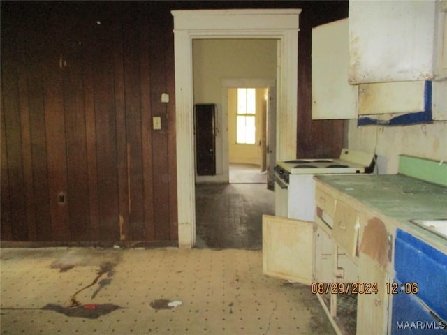 kitchen with electric range and wooden walls