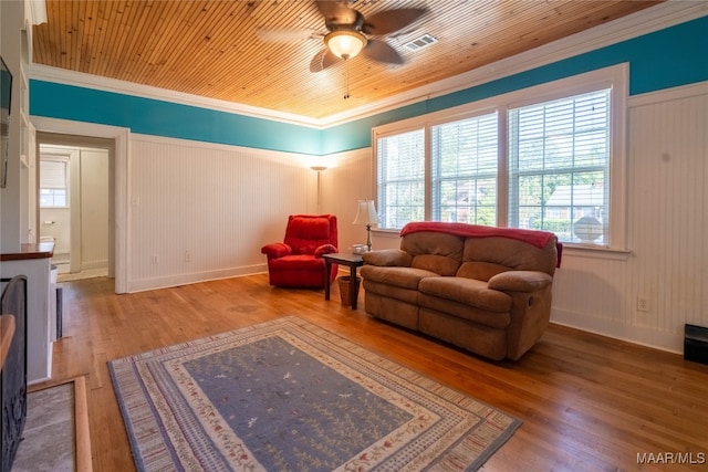 living room with crown molding, hardwood / wood-style floors, and a wealth of natural light