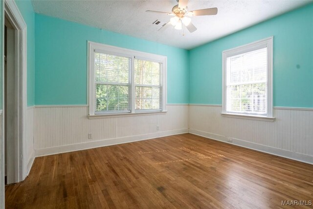 spare room featuring a textured ceiling, hardwood / wood-style flooring, and ceiling fan