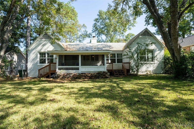 view of front of house with a front yard and a sunroom