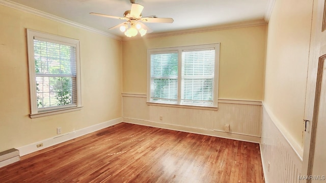 spare room with ceiling fan, hardwood / wood-style flooring, ornamental molding, and a baseboard heating unit