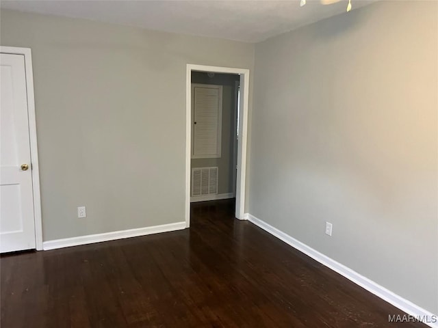 empty room with dark hardwood / wood-style flooring