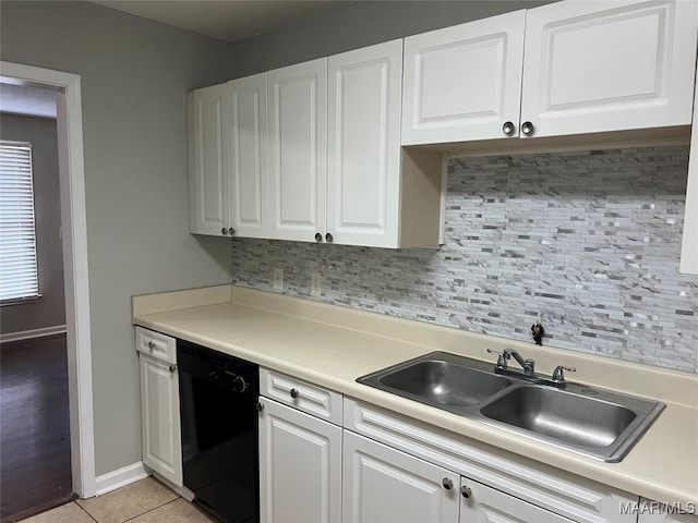 kitchen with white cabinetry, black dishwasher, decorative backsplash, and light tile patterned floors