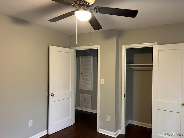 unfurnished bedroom featuring dark hardwood / wood-style floors, ceiling fan, and a closet