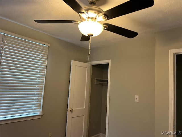 unfurnished bedroom featuring ceiling fan and a closet