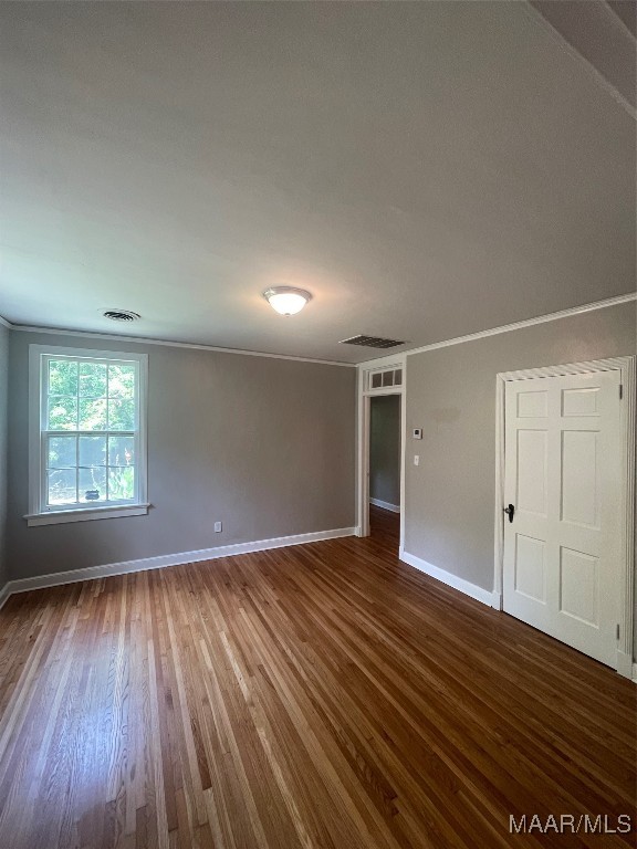 spare room featuring crown molding and hardwood / wood-style floors