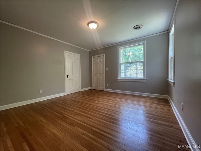 unfurnished room featuring dark wood-type flooring and crown molding