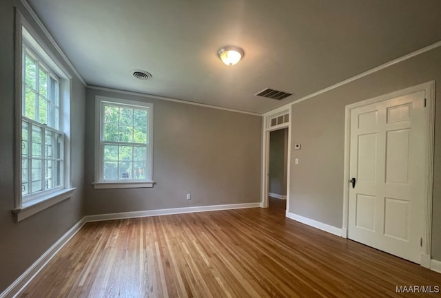 unfurnished room featuring crown molding and hardwood / wood-style flooring