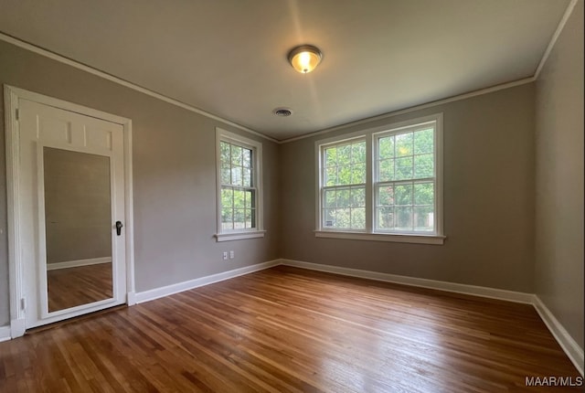 unfurnished bedroom featuring crown molding and hardwood / wood-style flooring