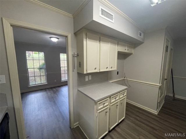 kitchen with white cabinets, dark hardwood / wood-style floors, and ornamental molding