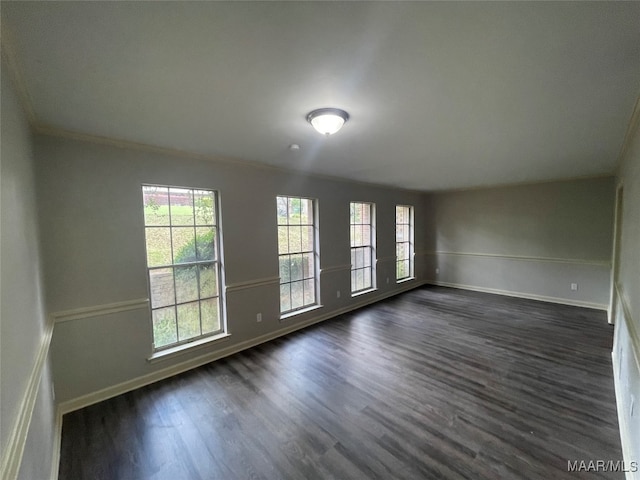 empty room featuring ornamental molding and dark hardwood / wood-style flooring