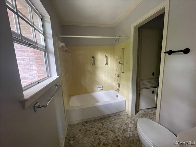 bathroom featuring crown molding, toilet, tile patterned floors, and tiled shower / bath