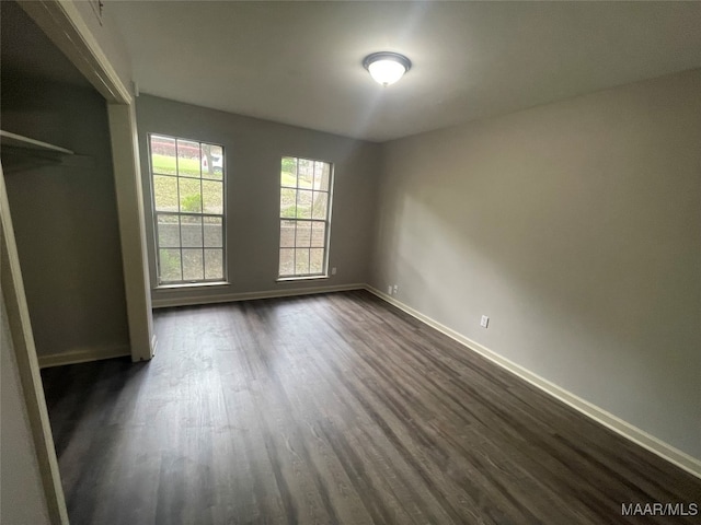 unfurnished bedroom featuring dark hardwood / wood-style flooring and a closet