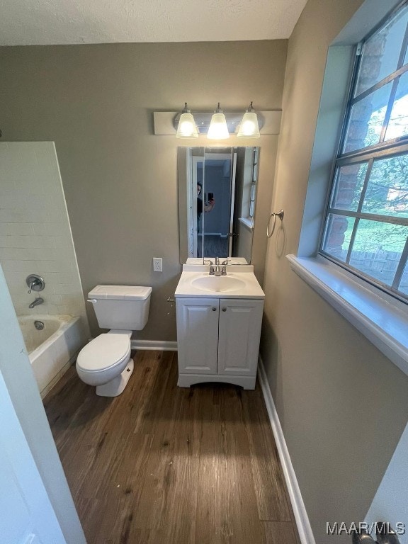 full bathroom with vanity, toilet, hardwood / wood-style floors, and tub / shower combination