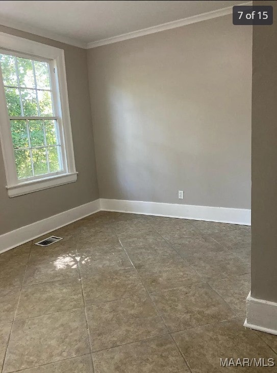 tiled spare room with ornamental molding