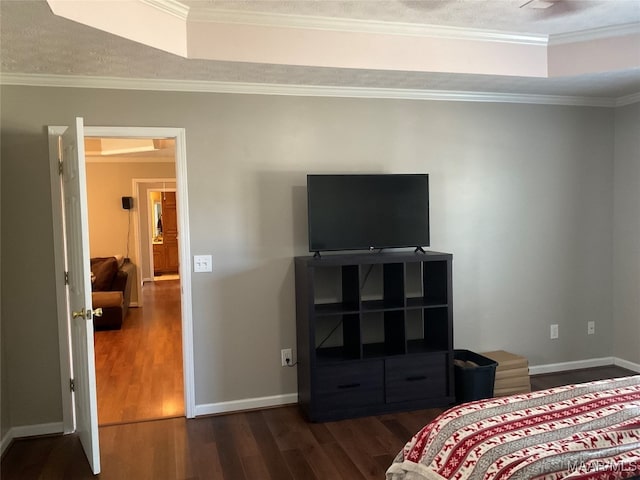 bedroom featuring ornamental molding, a raised ceiling, and dark hardwood / wood-style flooring