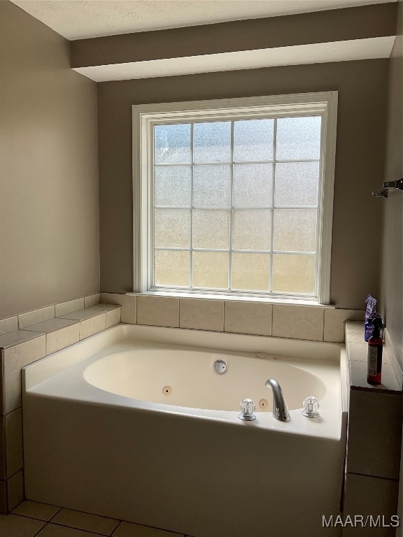 bathroom with plenty of natural light, a bathing tub, and tile patterned floors