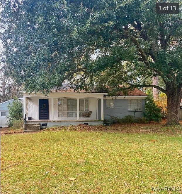 ranch-style home with covered porch and a front yard