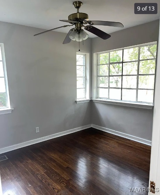 spare room with dark hardwood / wood-style flooring and ceiling fan