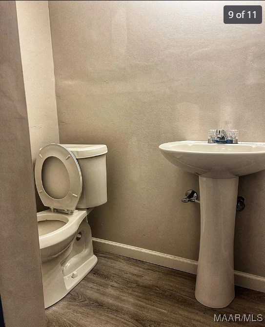 bathroom with hardwood / wood-style floors and toilet