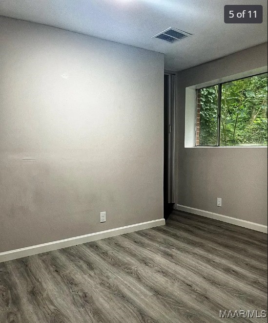 unfurnished room featuring dark wood-type flooring