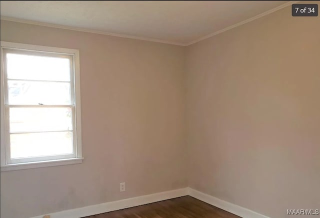 empty room with dark hardwood / wood-style floors, crown molding, and a healthy amount of sunlight