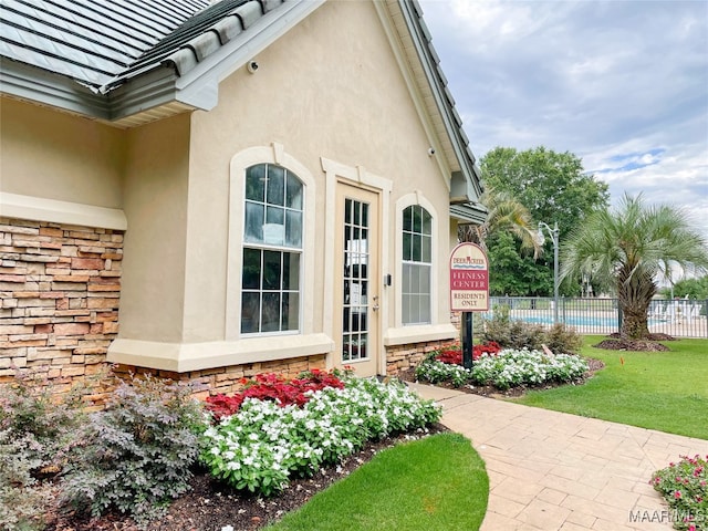 view of exterior entry with a lawn