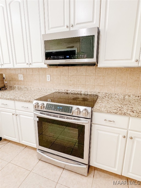 kitchen featuring white cabinets, backsplash, stainless steel appliances, and light tile patterned flooring