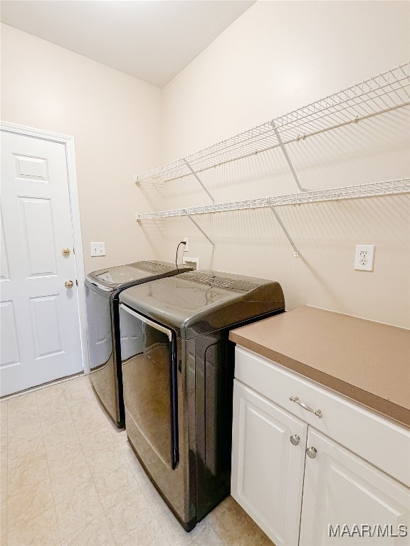 washroom with separate washer and dryer and cabinets