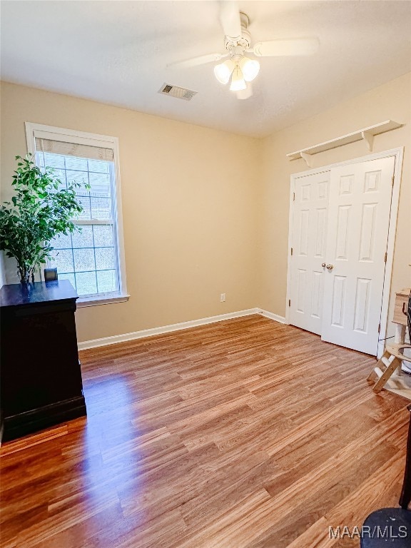 unfurnished bedroom with a closet, wood-type flooring, and ceiling fan