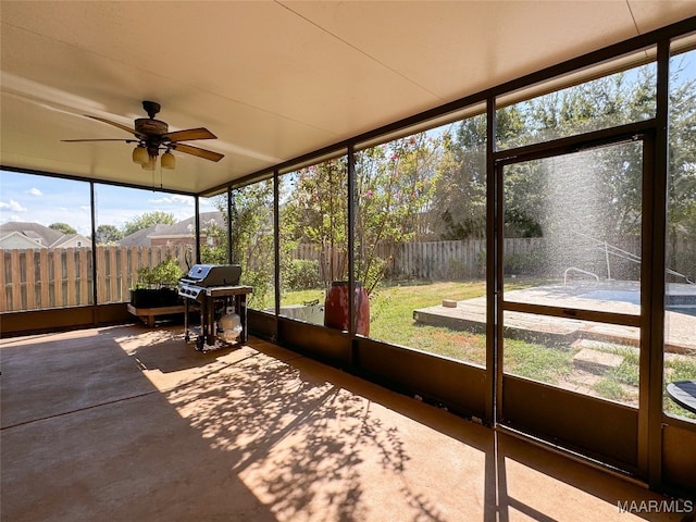 unfurnished sunroom featuring ceiling fan