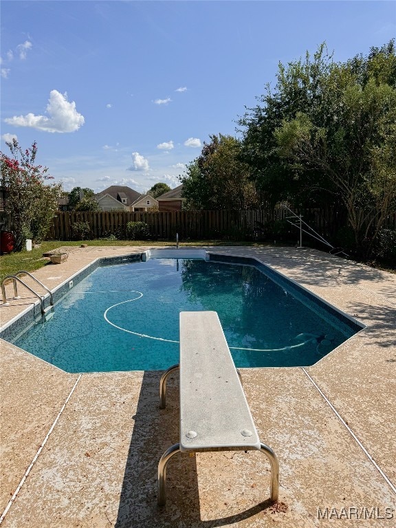 view of pool with a diving board