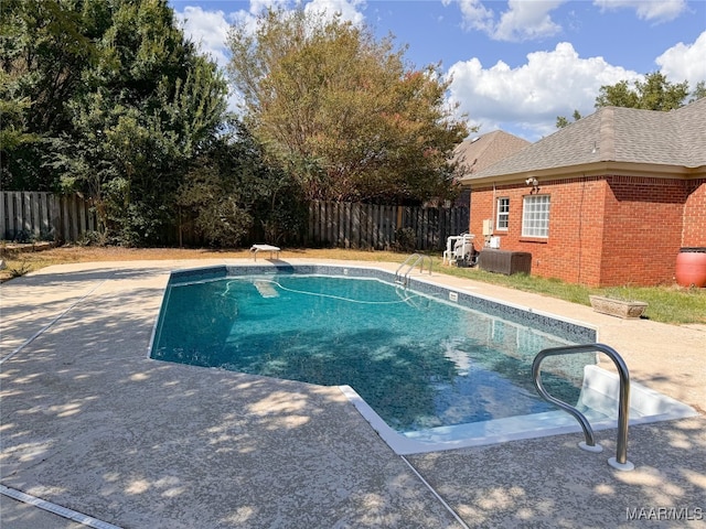 view of swimming pool featuring a diving board and a patio area